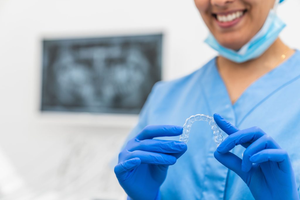 close up of a smiling dental hygienist holding a c 2026 03 24 00 22 49 utc